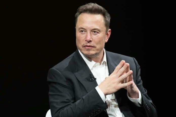 Man in suit, hands clasped, black background.