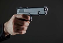 Hand holding a semi-automatic pistol pointed forward