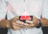 Hands holding a smartphone with warning icons overlay