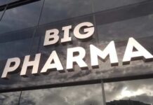 Sign displaying the words BIG PHARMA on a glass building