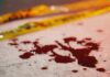 Blood droplets on pavement near yellow caution tape
