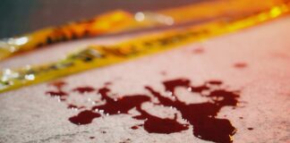 Blood droplets on pavement near yellow caution tape