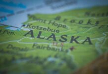 Map of Alaska with a small American flag