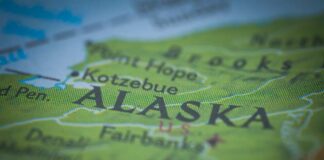 Map of Alaska with a small American flag