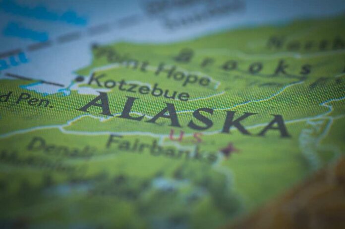 A,Map,With,Selective,Focus,Sharply,Highlights,The,Word,"alaska," Map of Alaska with a small American flag