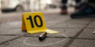 Bullet casing on the ground next to a numbered evidence marker