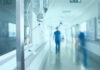 Hospital corridor with IV drip and healthcare worker.
