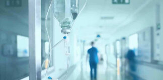 Hospital corridor with IV drip and healthcare worker.