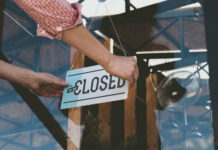 Coffee Giant Hit Hard – Massive Store Closings Person flipping closed sign on glass door