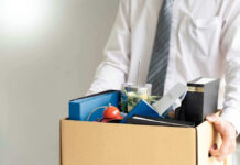 Person holding a box of personal office items.