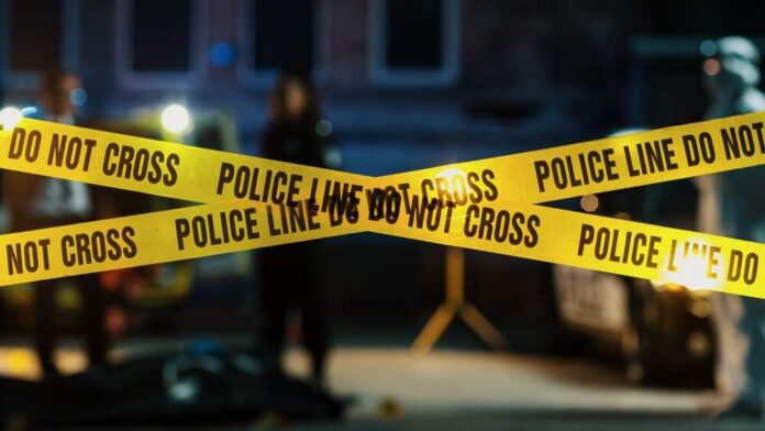 Restricted,Area:,Yellow,Tape,Showing,Text,"police,Line,Do,Not Police tape marking a crime scene with blurred figures in the background