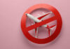 Trump Admin Alerts SURGE – Flights At Risk?! Airplane inside red prohibition sign on pink background.