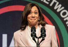 Kamala Harris speaking at a podium with two microphones