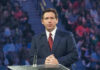 Ron DeSantis at a podium during an event; Christian Jones not visible