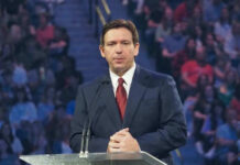 Ron DeSantis at a podium during an event; Christian Jones not visible