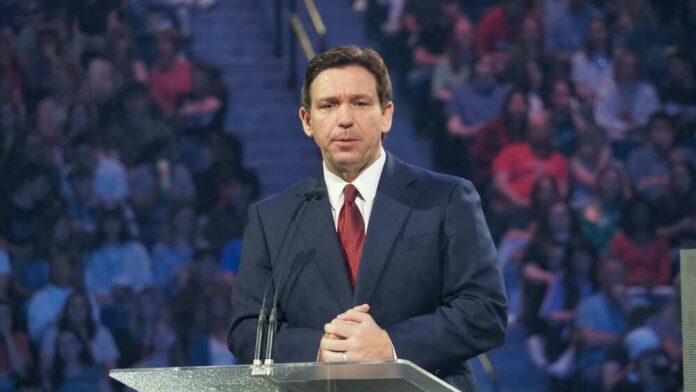 Ron DeSantis at a podium during an event; Christian Jones not visible