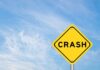 Yellow warning sign reading crash against blue sky