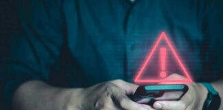 Person holding phone with warning symbol displayed.