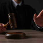 Pardon Bombshell Upends Clancy Child-Murder Case Judge holding gavel, hand raised in courtroom.