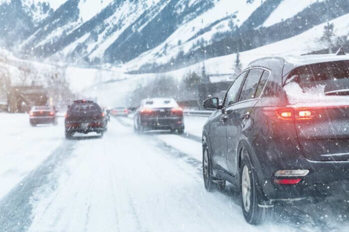 Cars driving on a snowy road in winter conditions