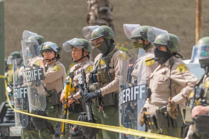 Dontrelle Inman and Danny White among sheriff deputies in riot gear holding shields