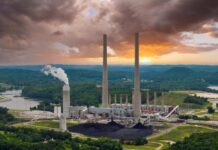 Coal-fired power plant with tall smokestacks at sunset