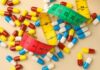 ALERT: Toxic Pills Recalled Nationwide Colorful capsules scattered with a measuring tape