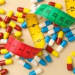 Colorful capsules scattered with a measuring tape