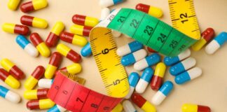 Colorful capsules scattered with a measuring tape