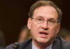 Samuel Alito speaking into a microphone