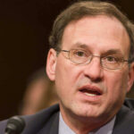 Samuel Alito speaking into a microphone