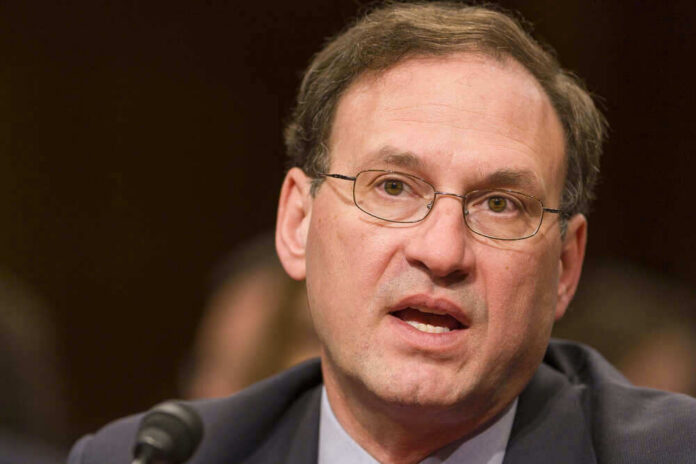 Samuel Alito speaking into a microphone