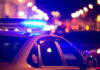 Police car with flashing blue lights at night.
