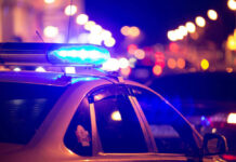 Three Masked Men Target Famous Woman Athlete Police car with flashing blue lights at night.
