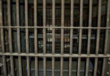 Scorching Prison Cells Trigger THIS?! Empty, rusty barred jail cell with metal bunks.