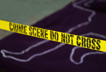 Yellow crime scene tape marking off an area with a chalk outline