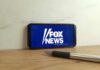 Smartphone displaying the Fox News logo on a wooden surface