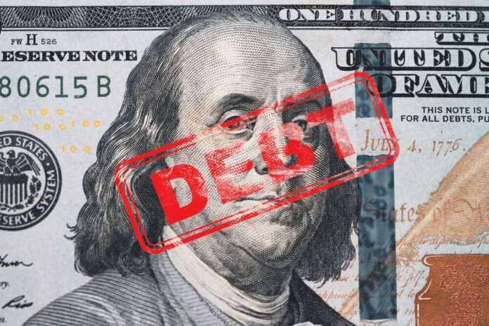 shutterstock_2407082349 Hundred dollar bill with red debt stamp