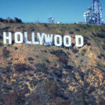 Hollywood sign on hillside with communication towers.
