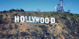 Hollywood sign on hillside with communication towers.