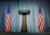 Podium between two American flags on a stage
