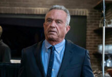 Robert F. Kennedy Jr. in a navy suit and blue shirt indoors