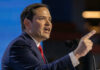 Marco Rubio speaking at a podium, pointing while addressing an audience