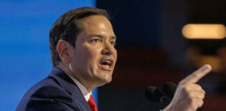 Marco Rubio speaking at a podium, pointing while addressing an audience