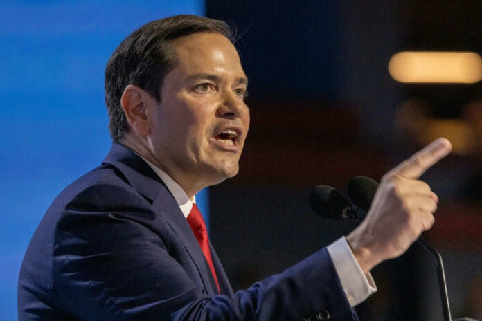 Marco Rubio speaking at a podium, pointing while addressing an audience