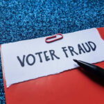 Paperclip holding paper labeled voter fraud marker