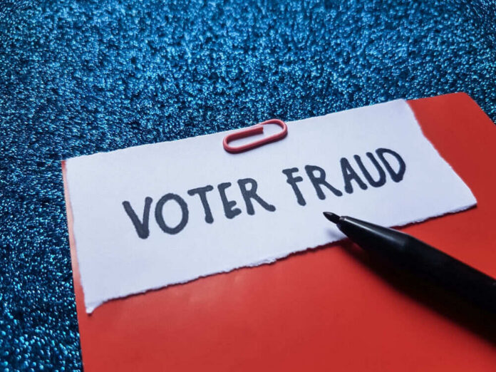 Paperclip holding paper labeled voter fraud marker