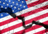Cracked United States flag on textured surface.