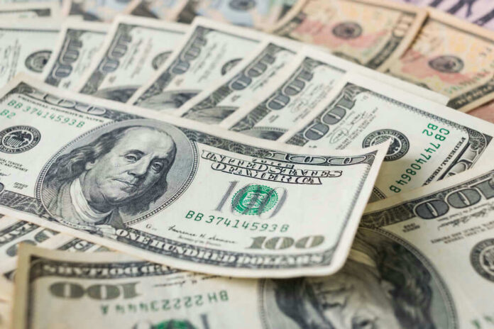 Stacks of various U.S. dollar bills.